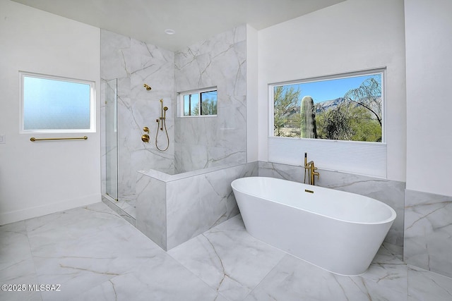 full bath with marble finish floor, a marble finish shower, and a freestanding bath