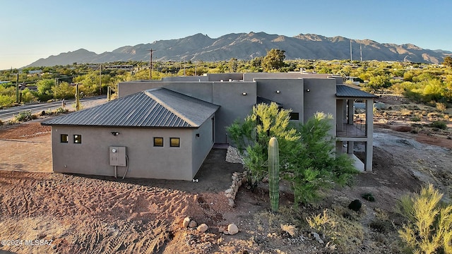 exterior space with stucco siding, metal roof, and a mountain view