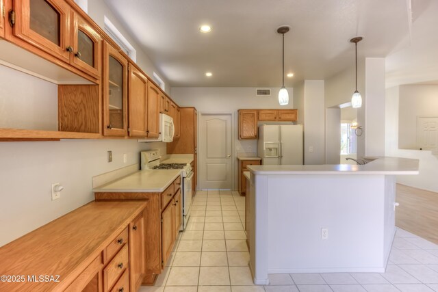13755 N Buster Spring Way, Oro Valley, AZ 85755 - kitchen with white appliances, glass insert cabinets, light tile patterned floors, light countertops, and brown cabinets