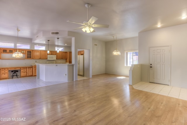 13755 N Buster Spring Way, Oro Valley, AZ 85755 - unfurnished living room with light wood-style flooring, a chandelier, and ceiling fan
