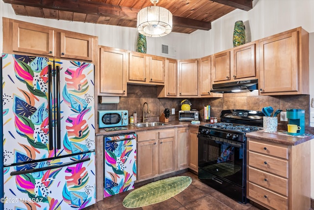 kitchen featuring a sink, black gas range, under cabinet range hood, dark countertops, and backsplash