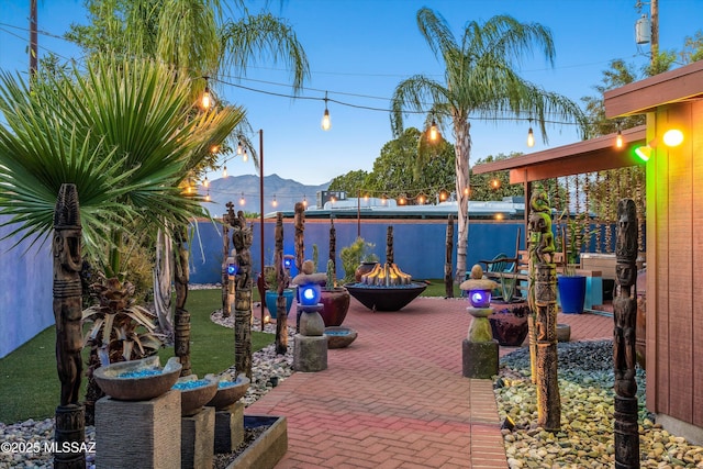 view of patio with a mountain view and a fire pit