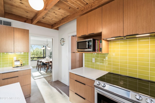 kitchen with light countertops, beamed ceiling, backsplash, and appliances with stainless steel finishes