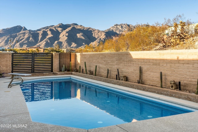 view of swimming pool featuring a mountain view, a fenced in pool, and a fenced backyard