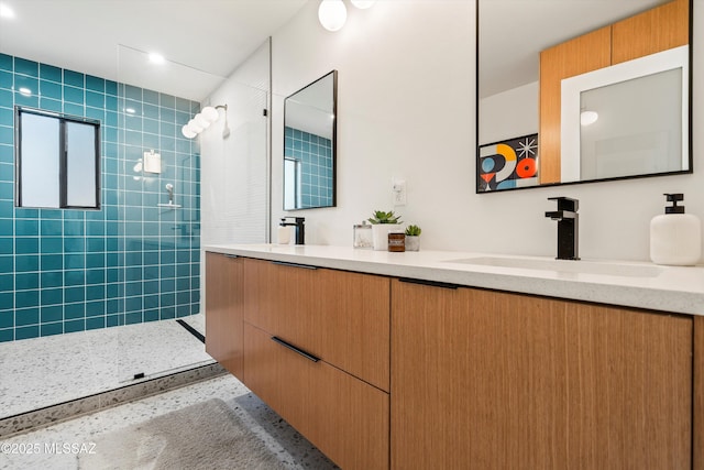 full bathroom with a sink, walk in shower, and double vanity