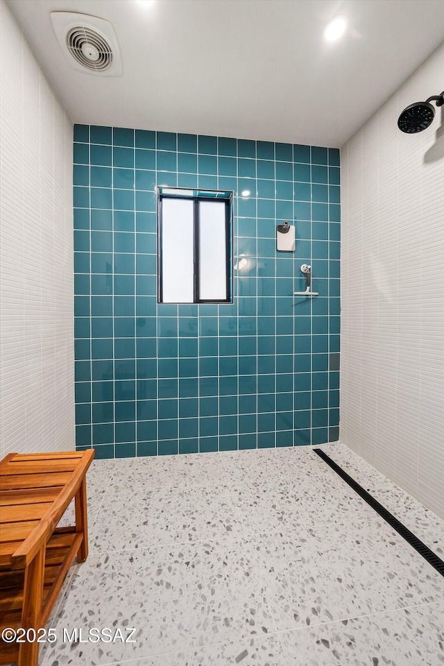 full bath with visible vents and tiled shower