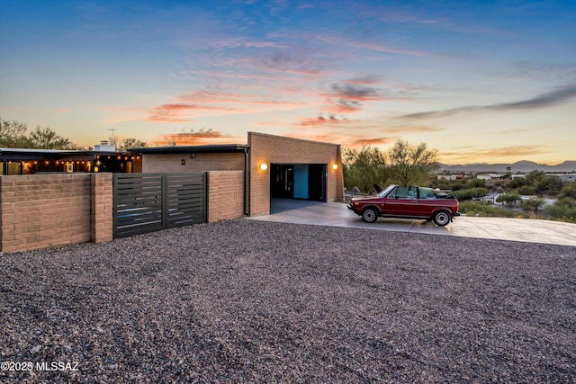 view of front of house with fence, brick siding, and driveway