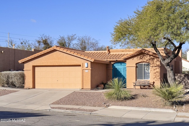 view of front of house with driveway, an attached garage, a tile roof, and stucco siding