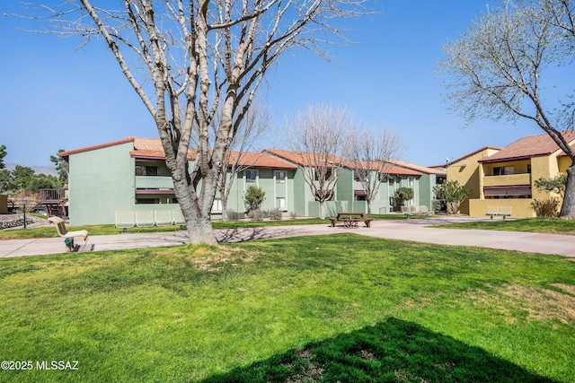 view of front of home featuring a front lawn, a residential view, and stucco siding