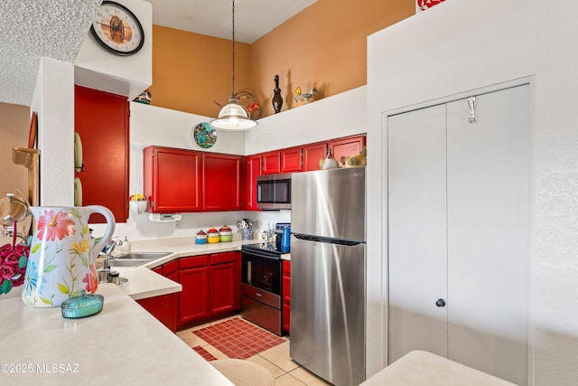 kitchen with light tile patterned floors, stainless steel appliances, light countertops, a sink, and dark brown cabinets