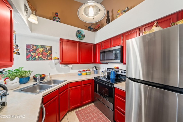 kitchen featuring dark brown cabinets, appliances with stainless steel finishes, light countertops, and a sink