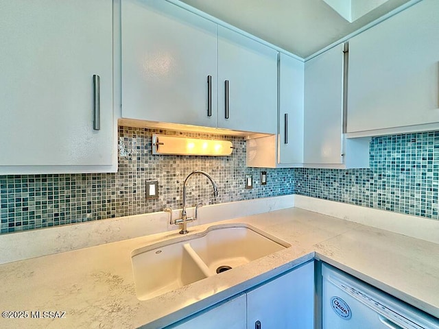 kitchen featuring tasteful backsplash, light countertops, and a sink