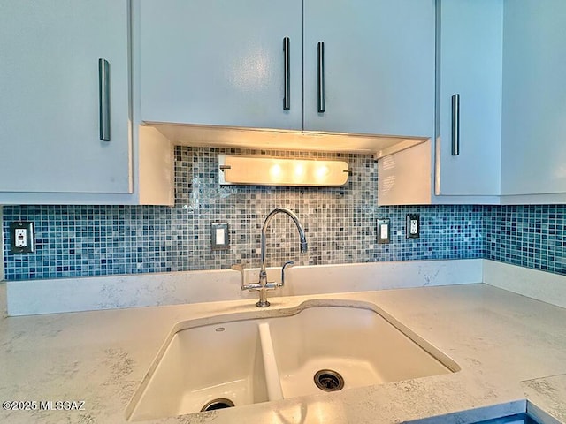 interior details featuring decorative backsplash, light countertops, and a sink