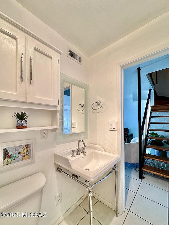 bathroom with visible vents, a sink, toilet, and tile patterned floors