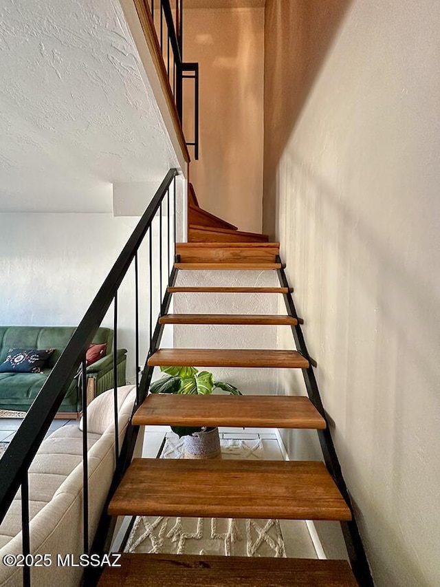 staircase with a textured ceiling