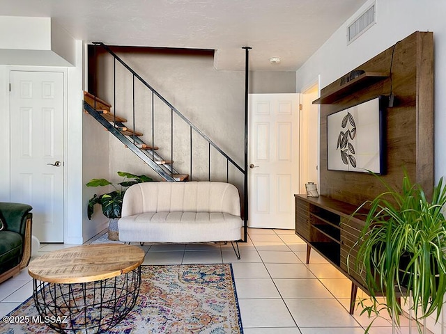 living room with light tile patterned floors, stairway, and visible vents