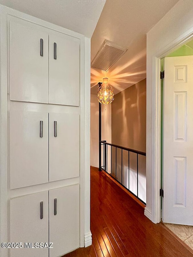 hall featuring hardwood / wood-style flooring and visible vents