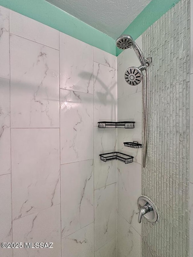 bathroom with a tile shower and a textured ceiling