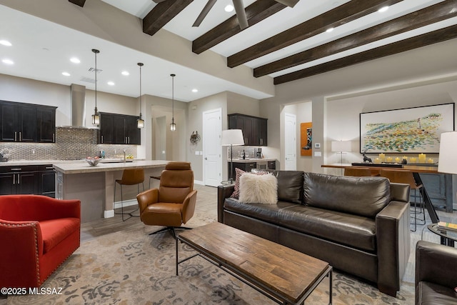 living room with a ceiling fan, recessed lighting, beam ceiling, and baseboards