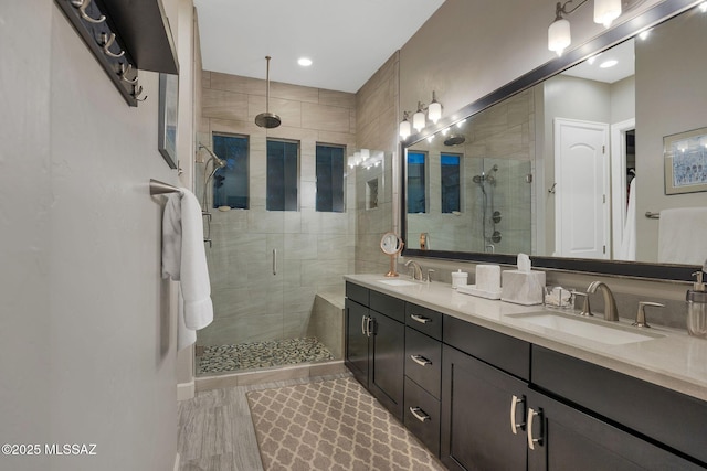 bathroom featuring double vanity, a sink, and a shower stall