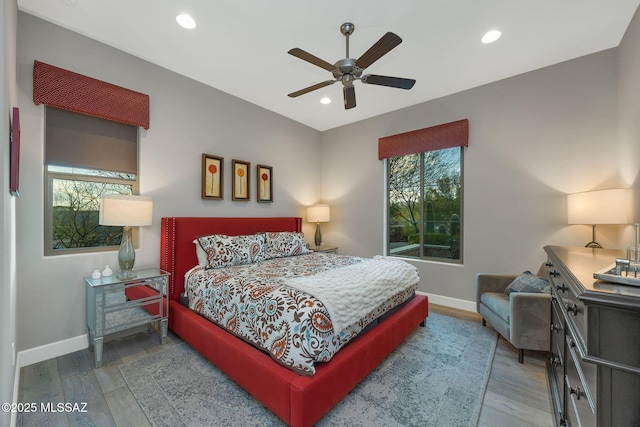 bedroom featuring recessed lighting, multiple windows, baseboards, and wood finished floors