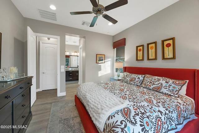 bedroom featuring baseboards, ceiling fan, visible vents, and wood finished floors