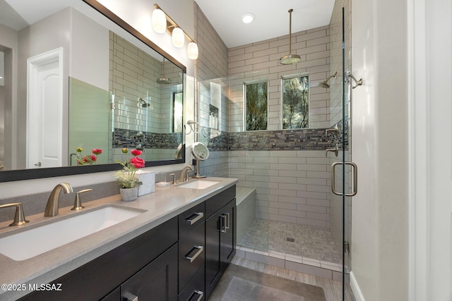 bathroom featuring double vanity, a stall shower, a sink, and tile patterned floors