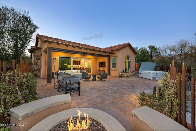 view of patio / terrace featuring a ceiling fan, an outdoor living space with a fire pit, and fence