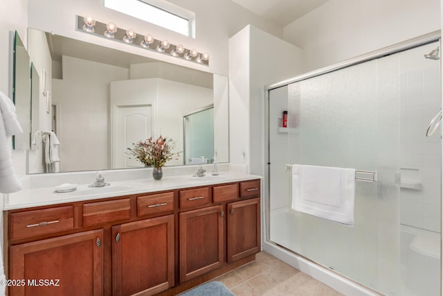 full bath featuring a stall shower, tile patterned flooring, a sink, and double vanity