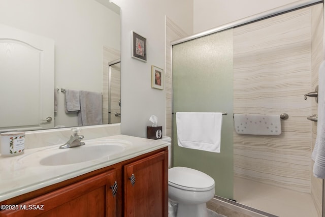 full bathroom featuring toilet, a shower with door, and vanity