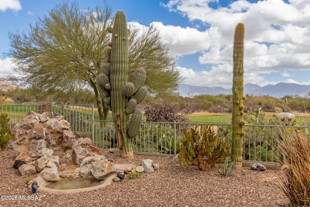 view of yard featuring fence and a mountain view