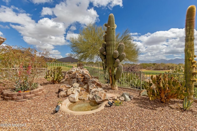 view of yard featuring fence and a mountain view