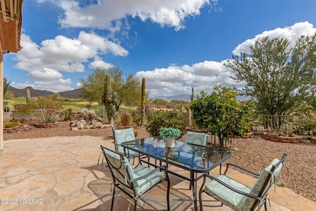 view of patio / terrace with fence, a mountain view, and outdoor dining area