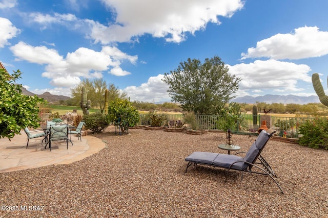 view of yard with a patio area, fence, and a mountain view