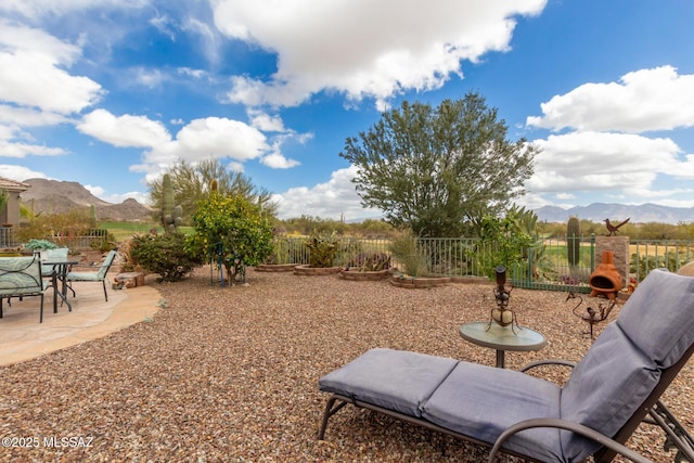 view of yard featuring a patio area, fence, and a mountain view