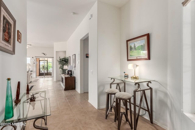 hallway with light tile patterned floors and baseboards