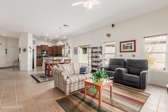 living area with light tile patterned floors, ceiling fan, visible vents, and recessed lighting