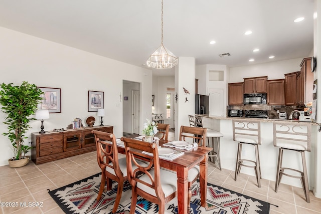 dining area with light tile patterned floors, recessed lighting, visible vents, and an inviting chandelier