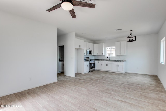 kitchen with appliances with stainless steel finishes, visible vents, light wood-style floors, and a sink