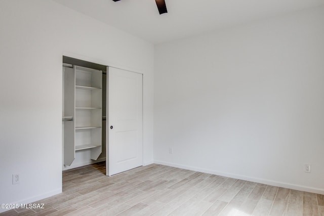 unfurnished bedroom with light wood-style floors, a closet, ceiling fan, and baseboards