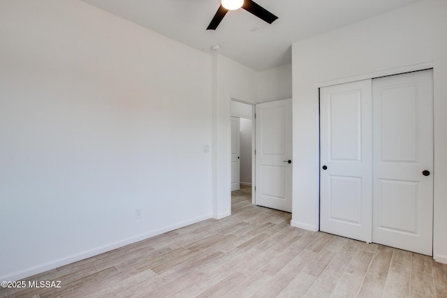 unfurnished bedroom with light wood-style floors, a closet, ceiling fan, and baseboards