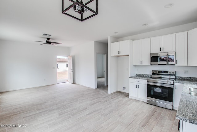 kitchen featuring a ceiling fan, white cabinetry, open floor plan, appliances with stainless steel finishes, and light wood finished floors