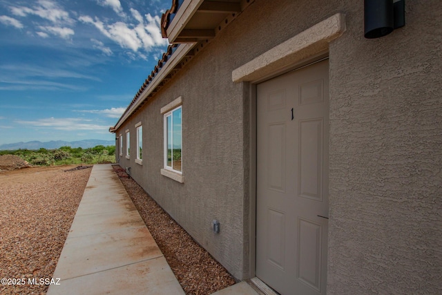 view of home's exterior with a mountain view and stucco siding