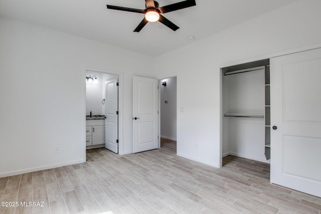 unfurnished bedroom featuring a closet, connected bathroom, light wood-style flooring, and baseboards