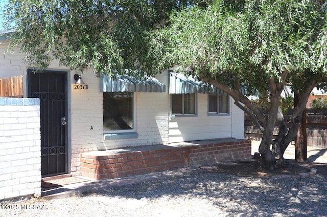 exterior space featuring brick siding and fence