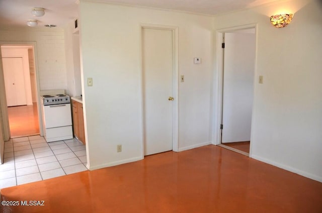 spare room featuring baseboards and light tile patterned flooring