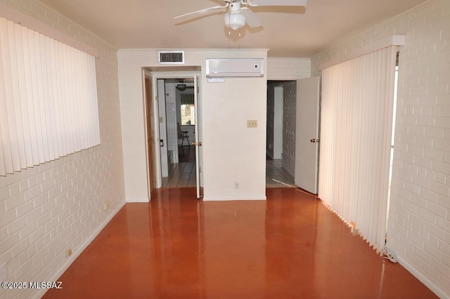 empty room featuring visible vents, a ceiling fan, finished concrete floors, brick wall, and a wall mounted air conditioner