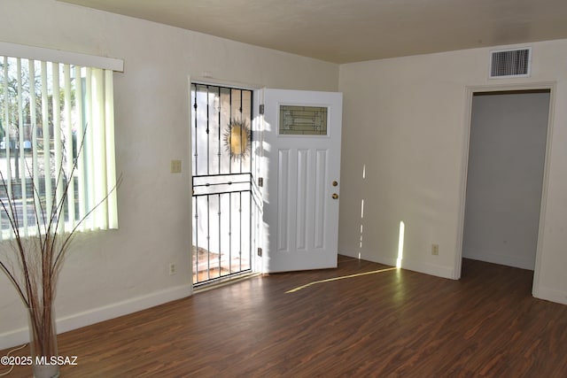 foyer with wood finished floors, visible vents, and baseboards