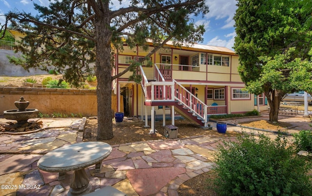 view of playground with a patio, stairway, and fence