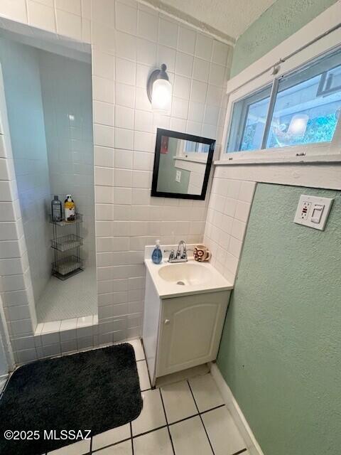 bathroom with tile walls, vanity, and tile patterned floors